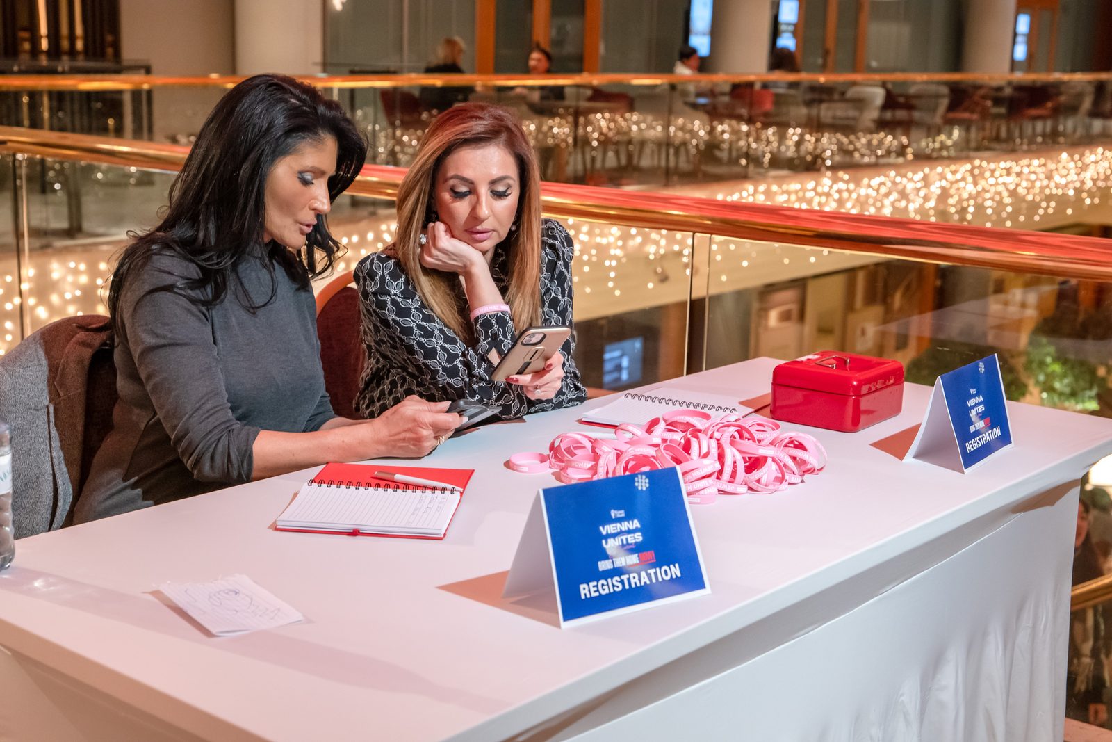 Anmeldetisch beim Vienna-Unites-Abend — Frauen mit den „Women Unite“-Armbändern
